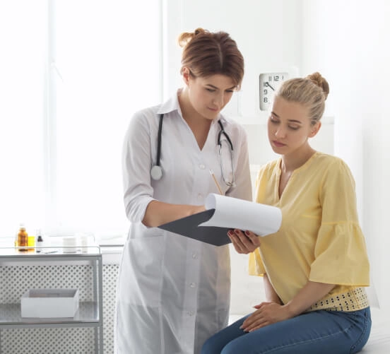 Dziewczyna w żółtej bluzce rozmawia z lekarką na temat HPV